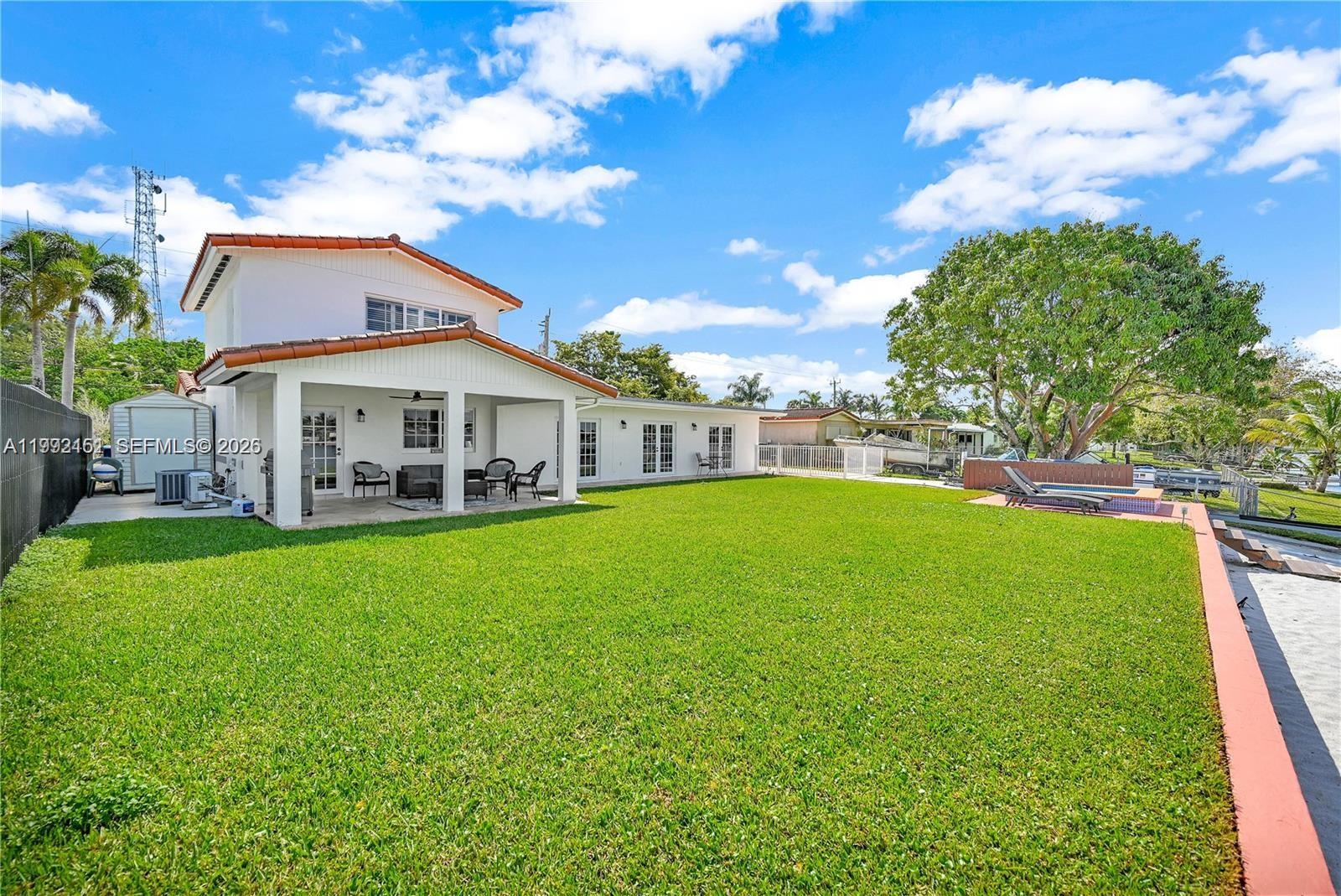 A two-story house with a covered patio, a large lawn, and a small pool — 18400 NW 78th Ave, Hialeah FL 33015, HIALEAH, FL
