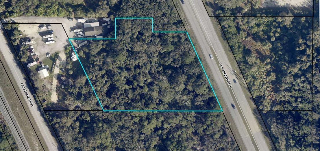 An aerial view shows a wooded, irregularly shaped parcel of land outlined in blue — 7585 Us-1, Vero Beach FL 32967, VERO BEACH, FL