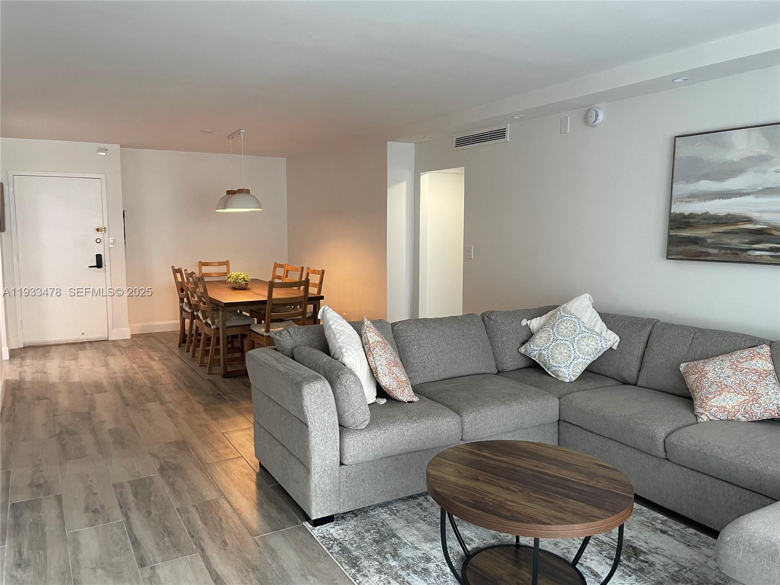 A living room with a gray sectional sofa and a dining area with a wooden table — 2030 S Ocean Dr # 805, Hallandale Beach FL 33009, HALLANDALE BEACH, FL