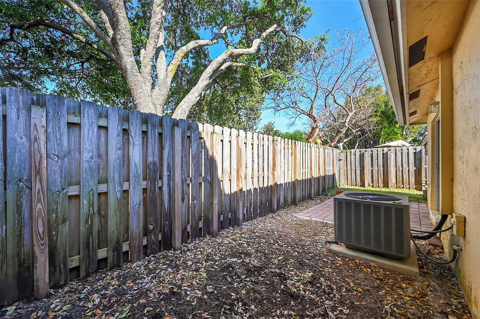 A backyard area features a wooden fence, an air conditioning unit, and a brick patio — 5361 NW 90th Avenue, Sunrise FL 33351, SUNRISE, FL