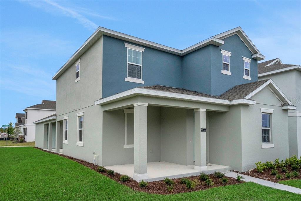 A two-story house with blue and light gray exterior walls and a covered front porch — 5276 SPADERDOCK LANE, APOPKA, FL