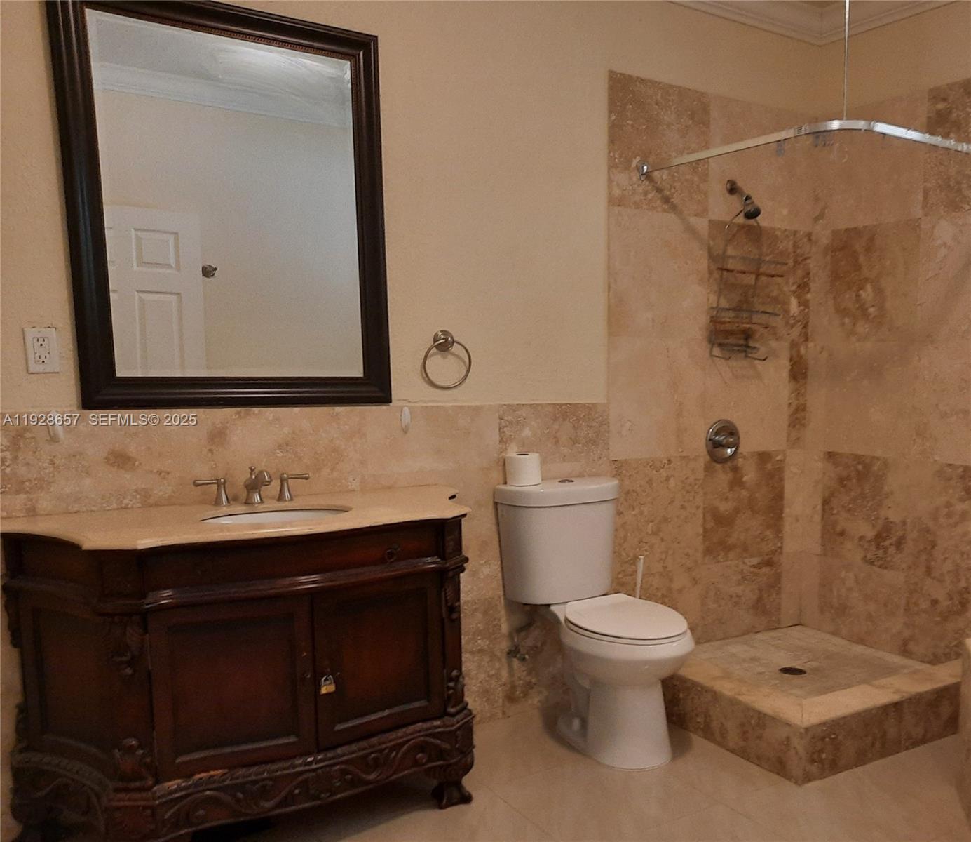A bathroom features a dark wood vanity, a toilet, and a walk-in tiled shower — 650 SW 44th Ct, Miami FL 33134, MIAMI, FL