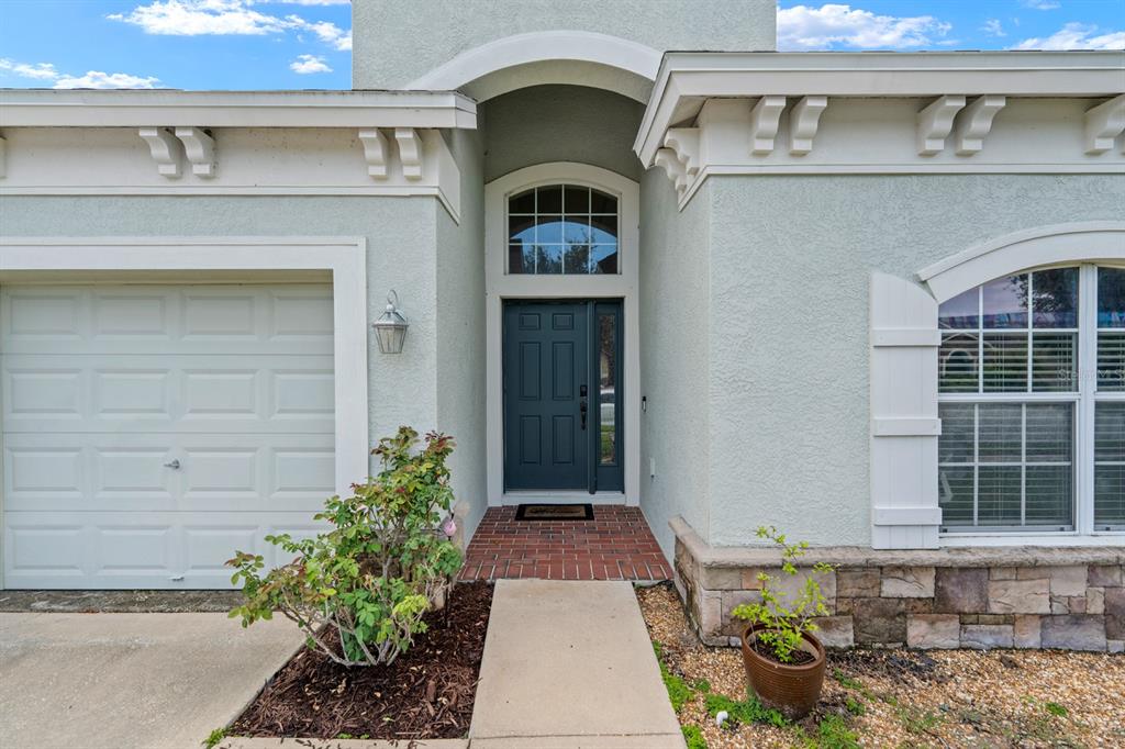 A single-story house with a three-car garage, stone accents, and a front lawn — 6751 BOULDER RUN LOOP, WESLEY CHAPEL, FL