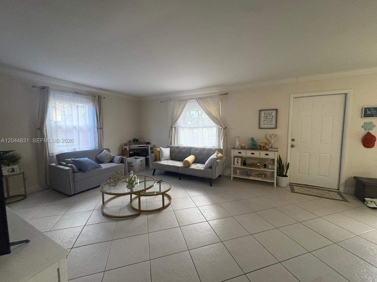 A living room features light tile flooring, two gray sofas, and a white console table — 4402 NW 5th Ave # 4402, Deerfield Beach FL 33064, DEERFIELD BEACH, FL