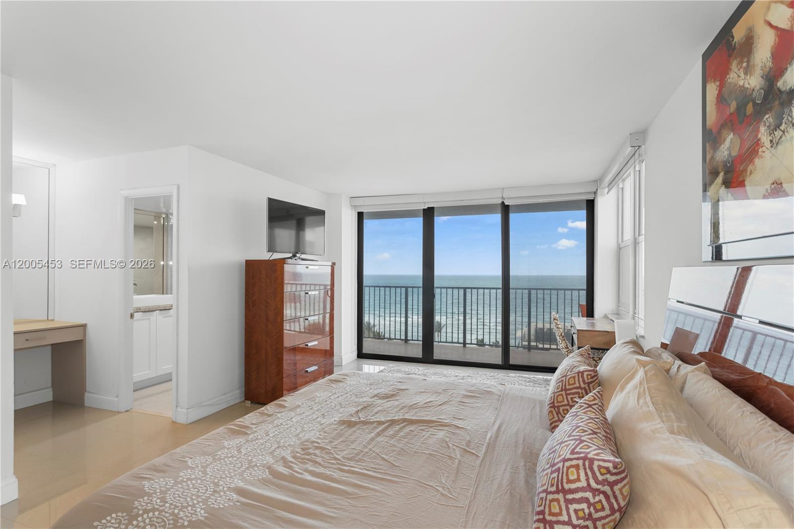 A bedroom features a bed, a dresser with a television, and a balcony overlooking the ocean — 2101 S Ocean # 1001, Hollywood FL 33019, HOLLYWOOD, FL