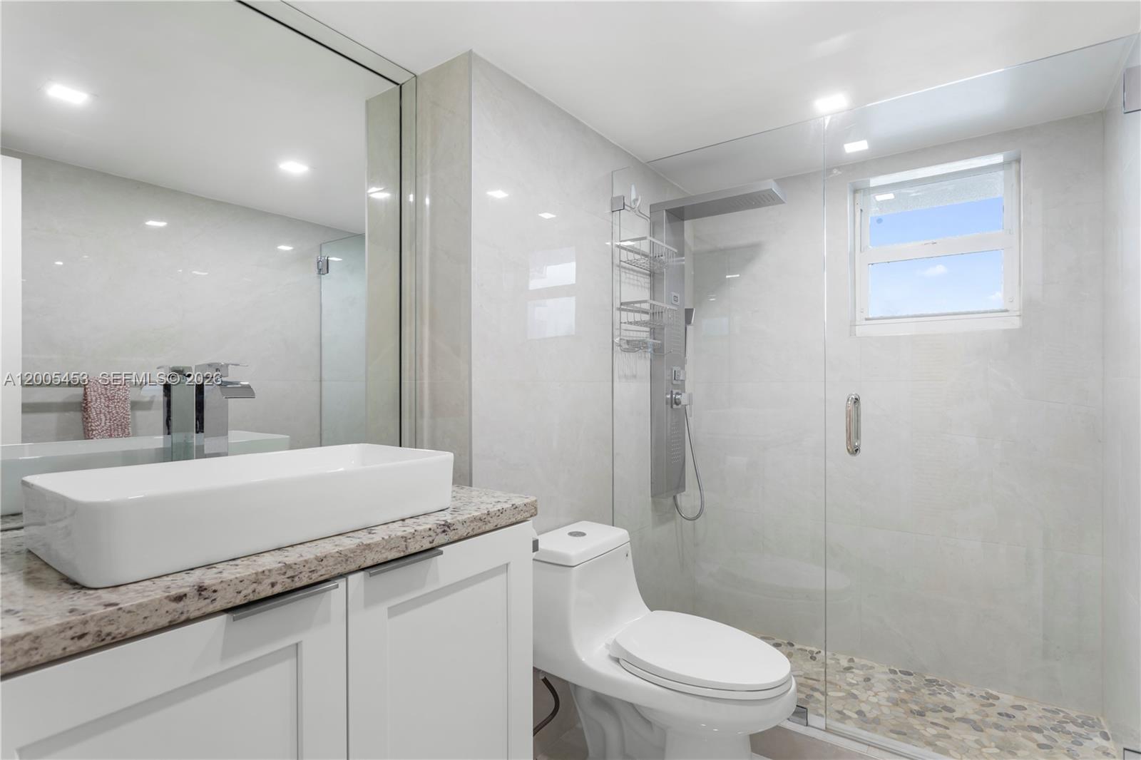 A modern bathroom features a vessel sink, granite countertop, white vanity, and a glass-enclosed shower — 2101 S Ocean # 1001, Hollywood FL 33019, HOLLYWOOD, FL