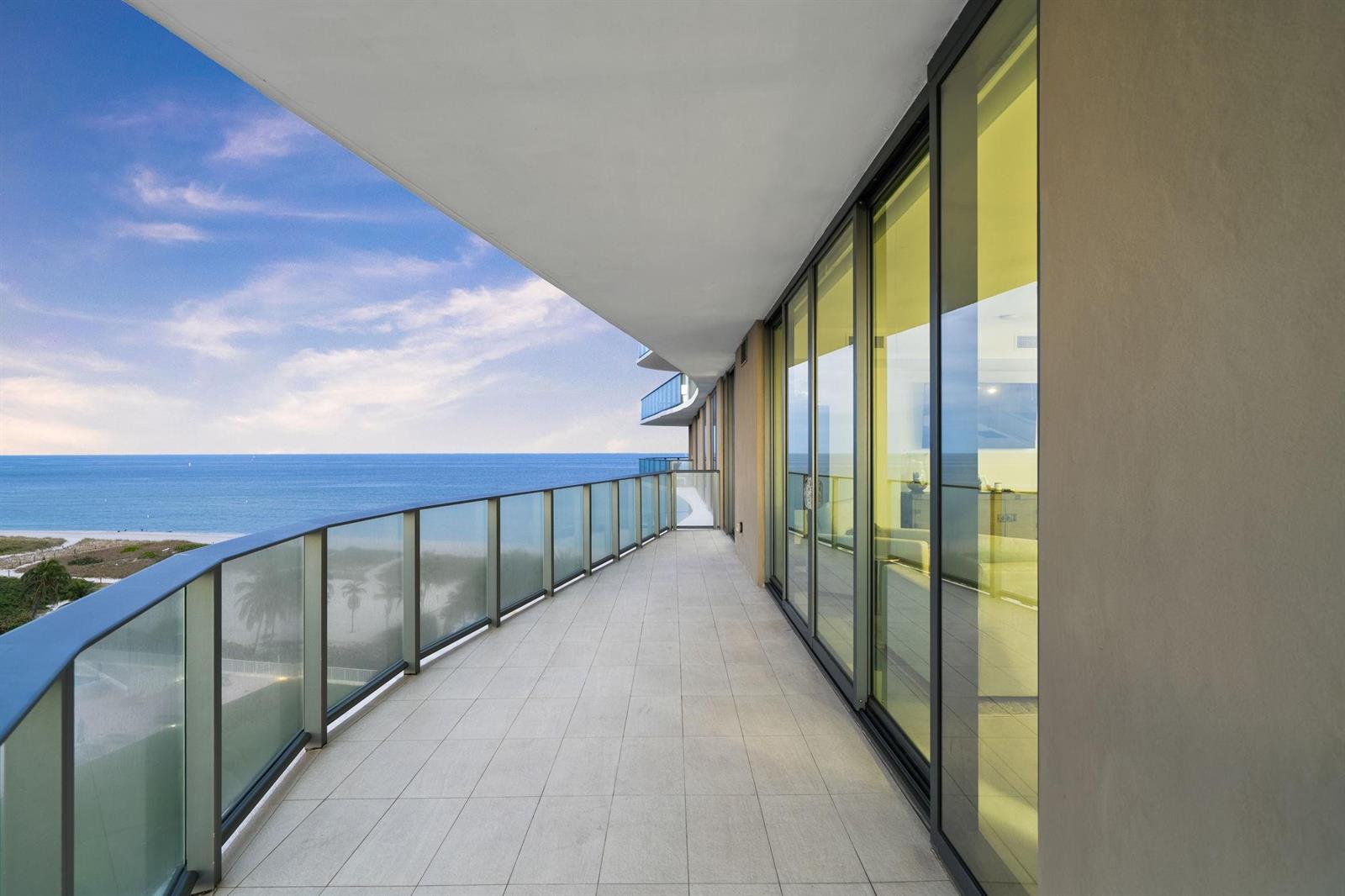 A wide balcony with glass railings overlooks the ocean and sandy beach — 730 N Ocean Boulevard # 701, Pompano Beach FL 33062, POMPANO BEACH, FL