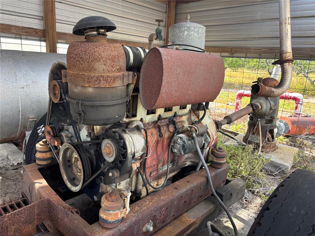 A rusty industrial engine is mounted on a metal frame under a shed roof — LAKE BUFFUM ROAD W, FORT MEADE, FL