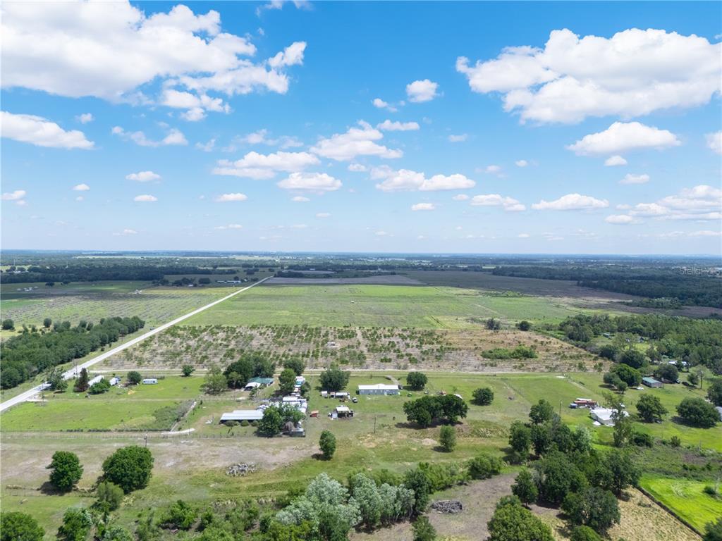 An aerial view shows a rural property with several buildings, trees, and open fields — LAKE BUFFUM ROAD W, FORT MEADE, FL