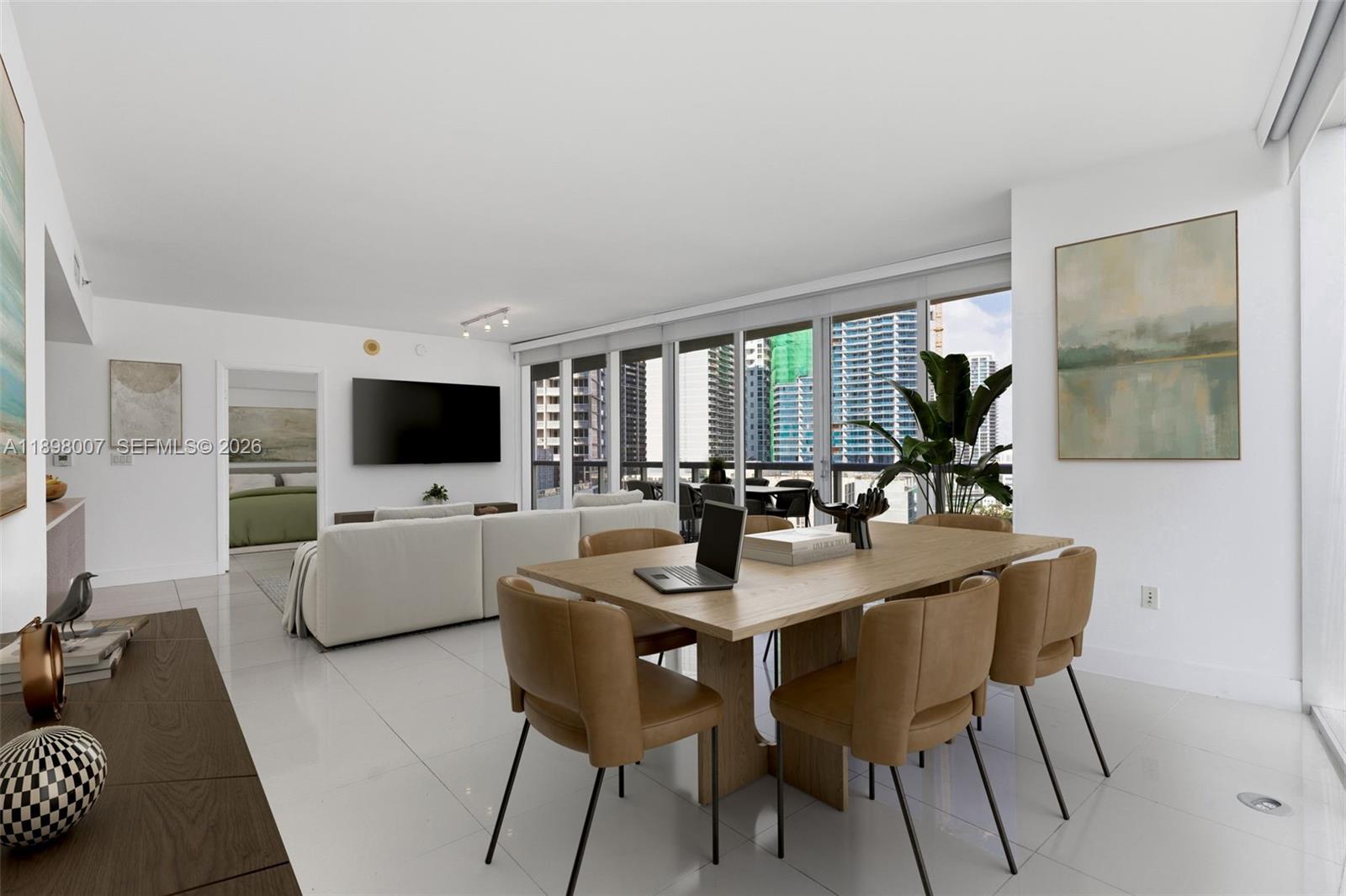 A modern living and dining area features white tile floors, tan chairs, and floor-to-ceiling windows — 465 Brickell Ave # 1602, Miami FL 33131, MIAMI, FL