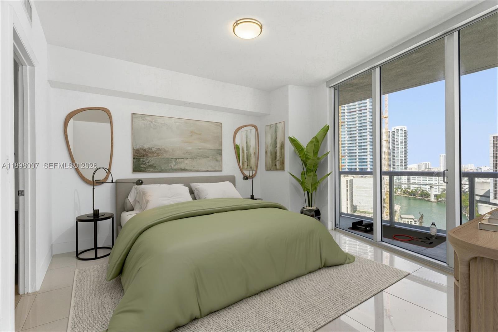 A modern bedroom features a green bed, asymmetrical mirrors, and a balcony with city views — 465 Brickell Ave # 1602, Miami FL 33131, MIAMI, FL