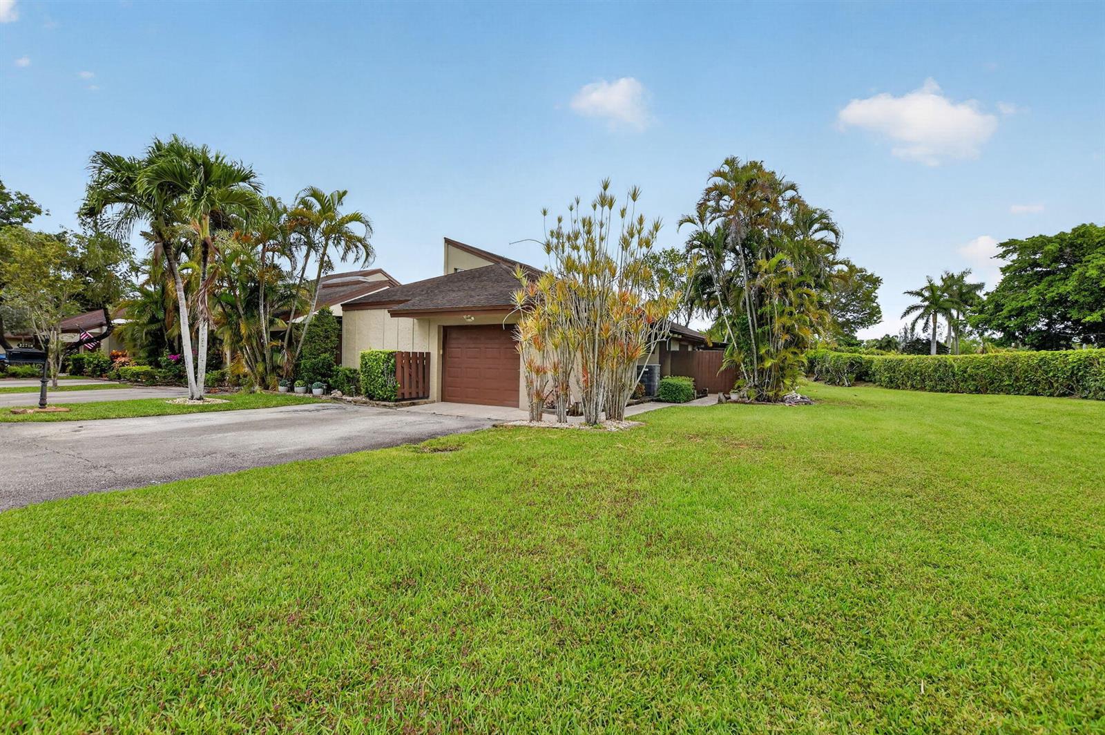 A single-story house with a brown garage door, palm trees, and a large front lawn — 22718 Vistawood Way, Boca Raton FL 33428, BOCA RATON, FL