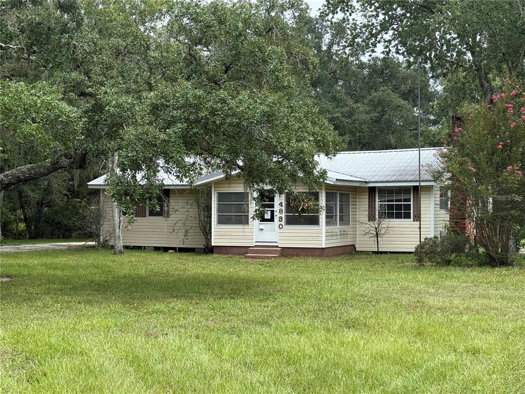 A single-story house with light siding and a metal roof sits on a grassy lot — 4830 SW 123RD ROAD, WEBSTER, FL