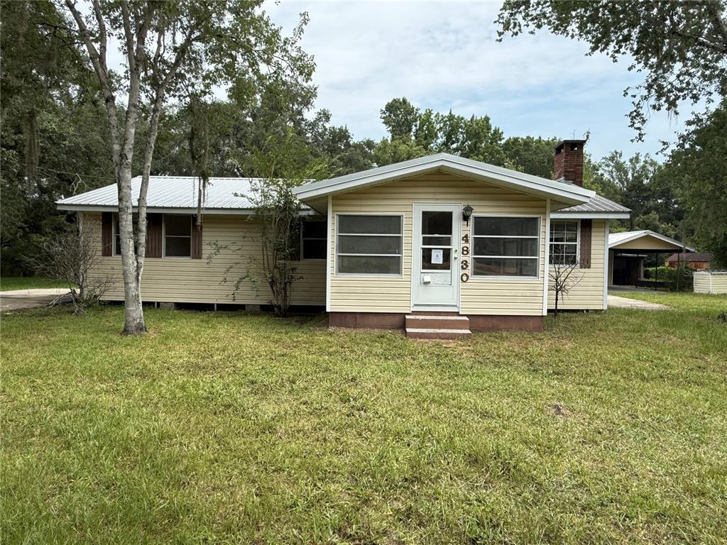 A single-story house with yellow siding, a metal roof, and a front porch — 4830 SW 123RD ROAD, WEBSTER, FL