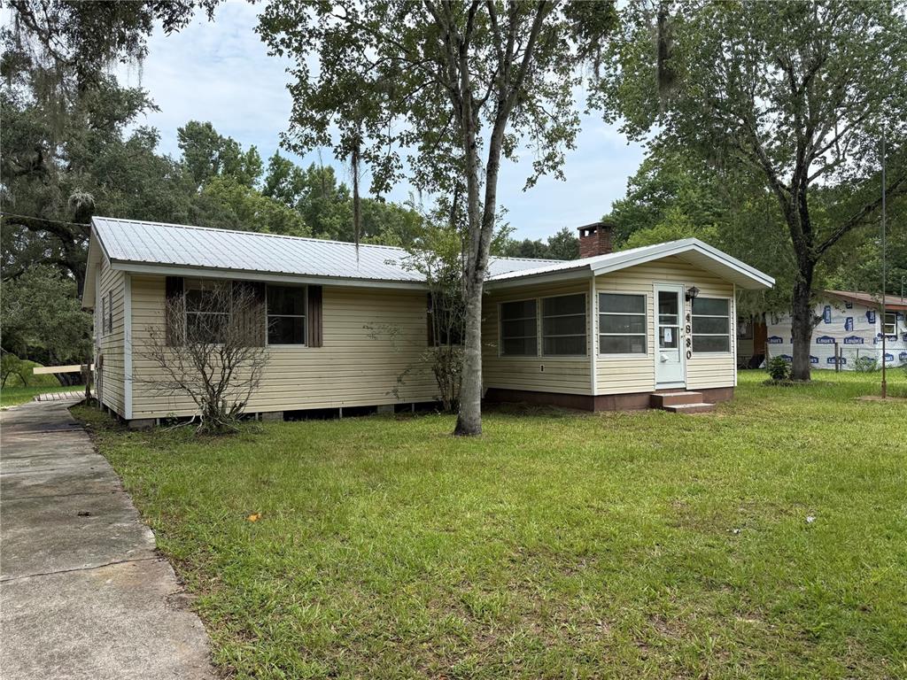 A single-story house with yellow siding, a metal roof, and a front porch — 4830 SW 123RD ROAD, WEBSTER, FL