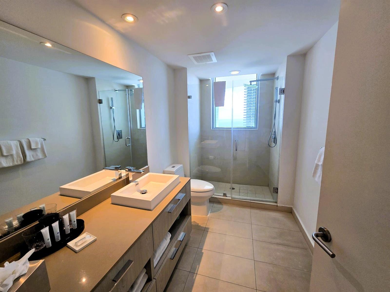 A modern bathroom features a floating vanity, a glass-enclosed shower, and a toilet — 4111 S Ocean Drive # 3011, Hollywood FL 33019, HOLLYWOOD, FL