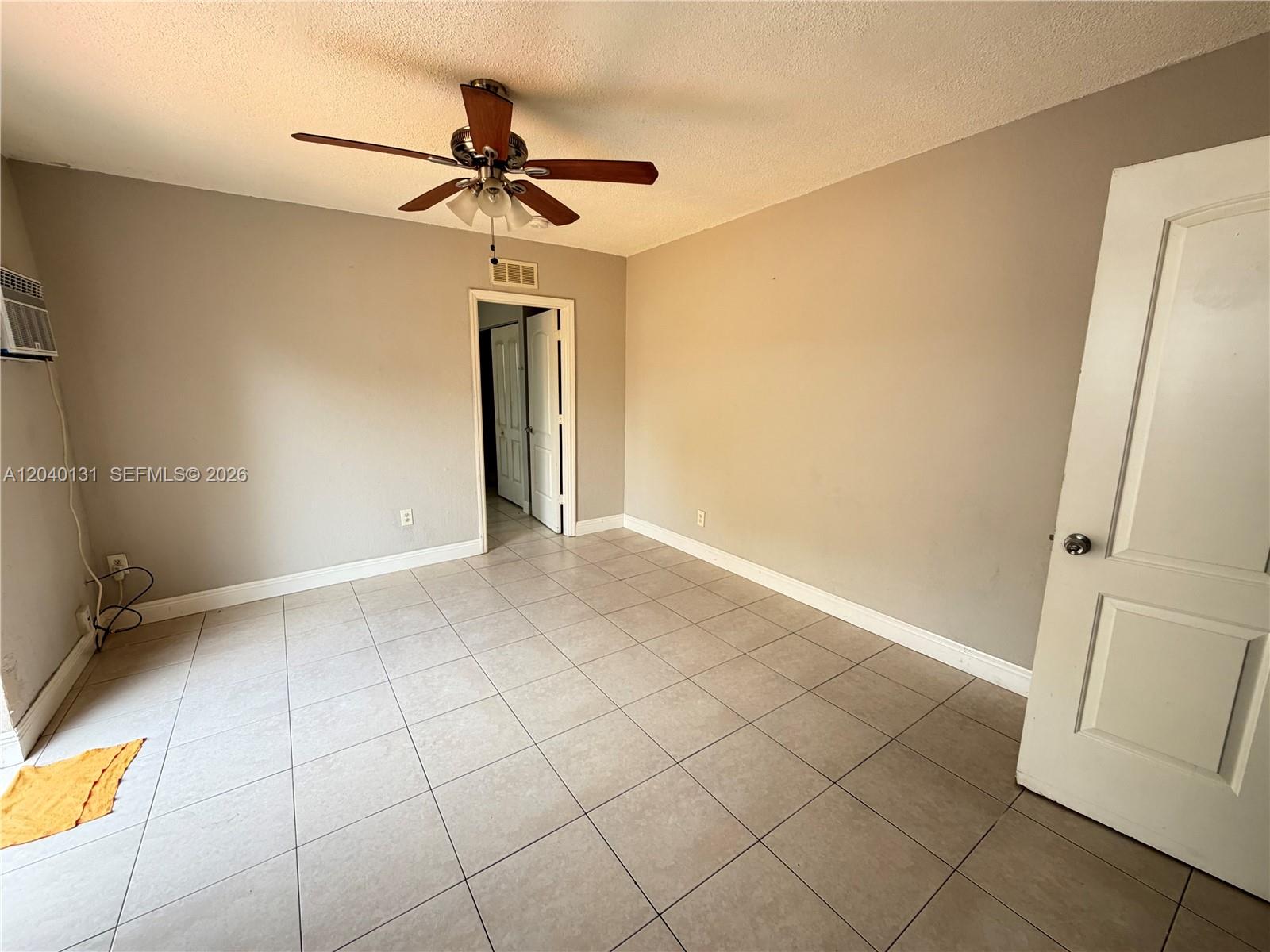 An empty room features light-colored tile flooring, gray walls, a ceiling fan, and a doorway — 6012 SW 38th St # 4, Miramar FL 33023, MIRAMAR, FL