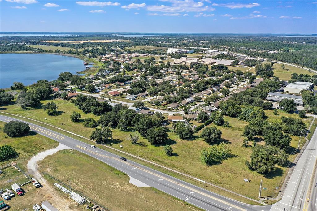 An aerial view shows a residential neighborhood situated next to a lake and highway — CR 448 Lot 1, TAVARES, FL