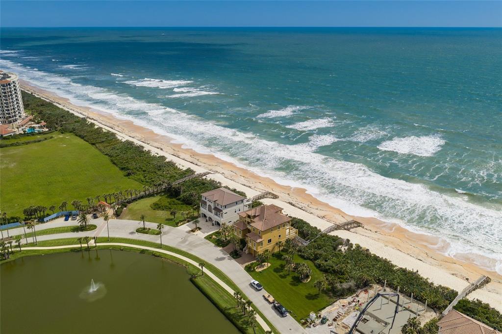 An aerial view shows two beachfront houses near a pond and the ocean — 35 CALLE DEL SUR, PALM COAST, FL