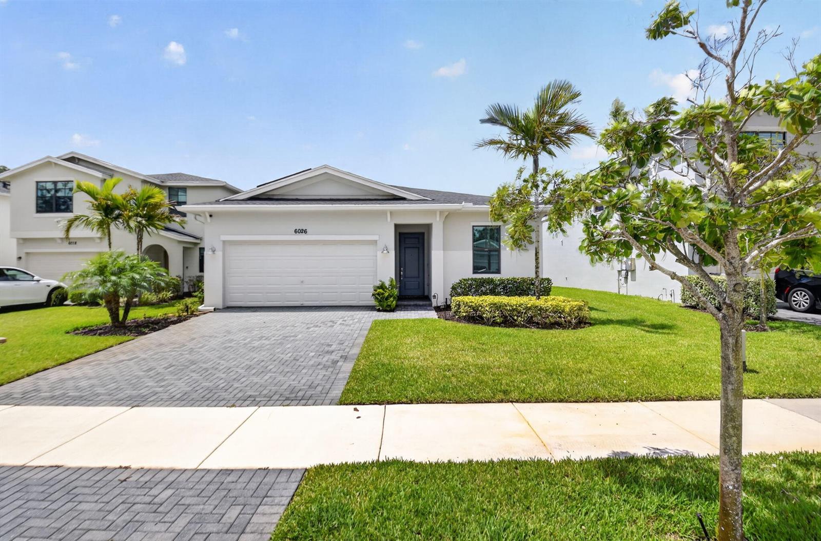 A single-story house with a white exterior, a two-car garage, and a paved driveway — 6026 Henderson Way, West Palm Beach FL 33415, WEST PALM BEACH, FL
