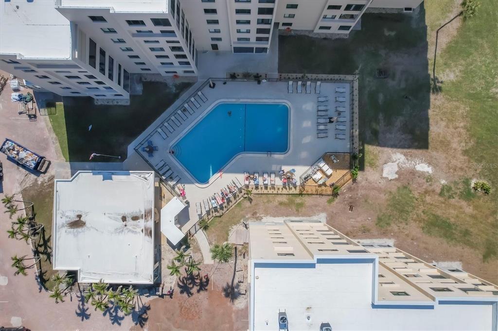 An aerial view shows a swimming pool and patio area situated between two large buildings — 6670 ESTERO BOULEVARD UNIT A104, FORT MYERS BEACH, FL