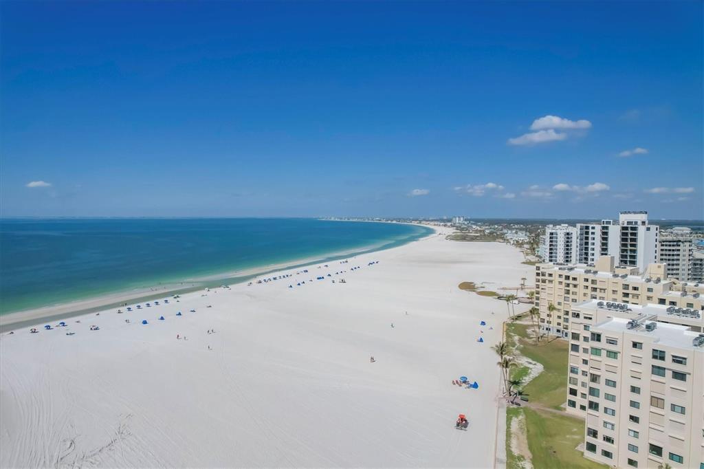 An aerial view shows a white sand beach along the ocean next to high-rise buildings — 6670 ESTERO BOULEVARD UNIT A104, FORT MYERS BEACH, FL