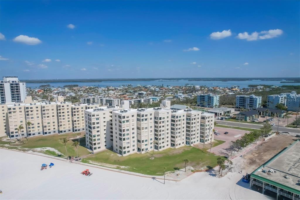 An aerial view of a multi-story apartment complex situated directly on a sandy beach — 6670 ESTERO BOULEVARD UNIT A104, FORT MYERS BEACH, FL