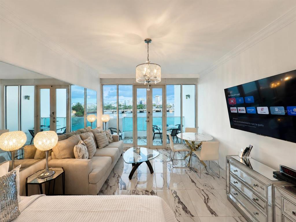 A living room with marble floors, a sofa, a dining set, and a balcony view — 1 CALLE SAN GERONIMO UNIT 319, SAN JUAN, PR