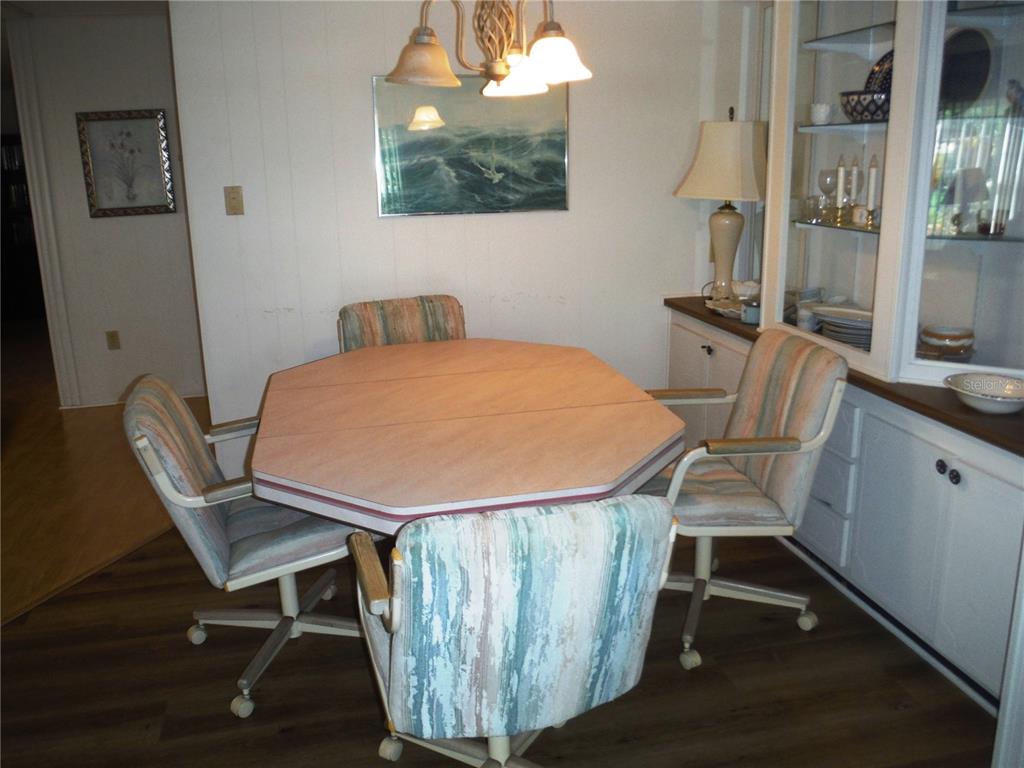 A dining room features an octagonal table, four rolling chairs, and a built-in china cabinet — 141 FOREST LANE UNIT 13, SAFETY HARBOR, FL