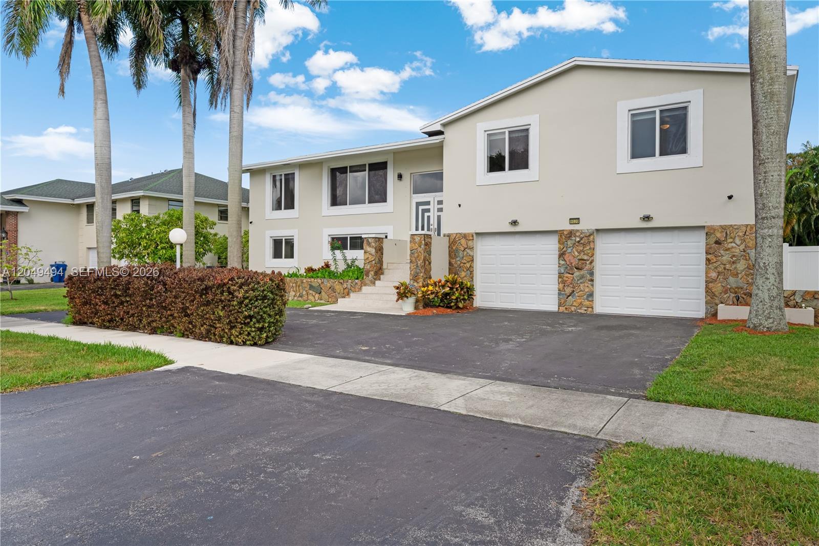 A two-story house features a stone-accented facade, a two-car garage, and a paved driveway — 8020 SW 198th St, Cutler Bay FL 33189, CUTLER BAY, FL