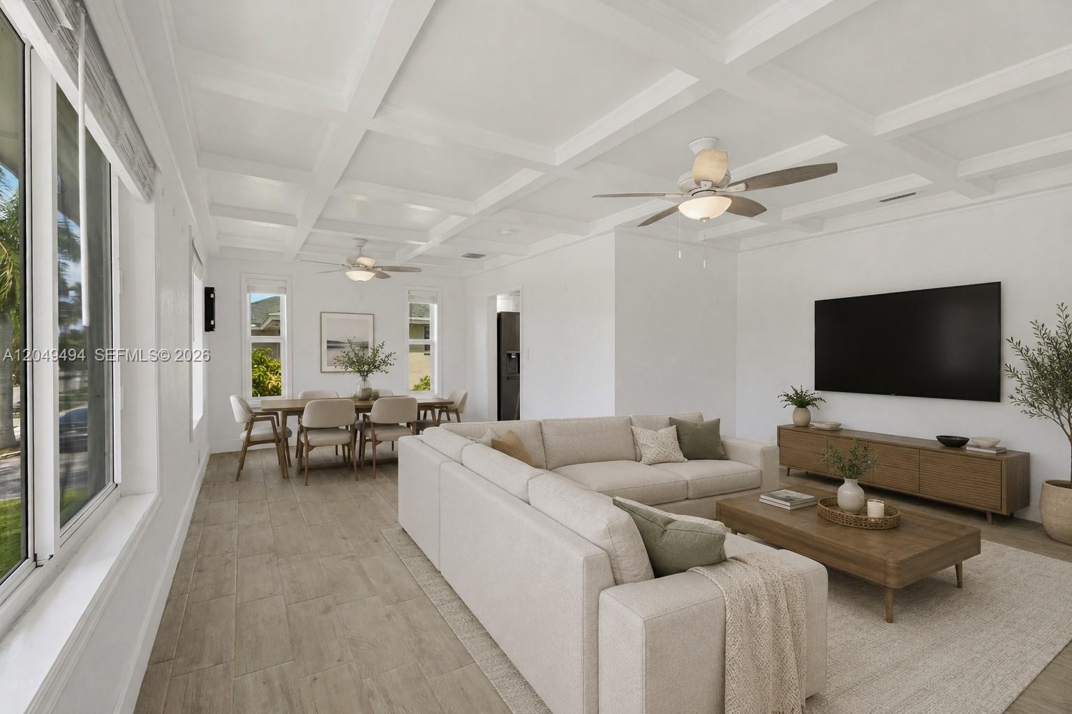 A bright living and dining area features a coffered ceiling, tile flooring, and neutral furniture — 8020 SW 198th St, Cutler Bay FL 33189, CUTLER BAY, FL