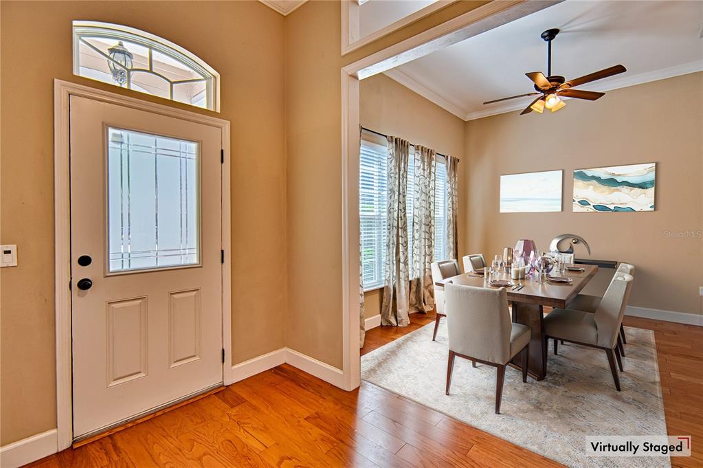 An entryway with hardwood floors leads into a dining room featuring a ceiling fan — 7546 SW 90 DRIVE, GAINESVILLE, FL