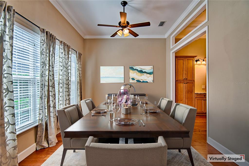 A dining room features a long wooden table, upholstered chairs, and a ceiling fan — 7546 SW 90 DRIVE, GAINESVILLE, FL