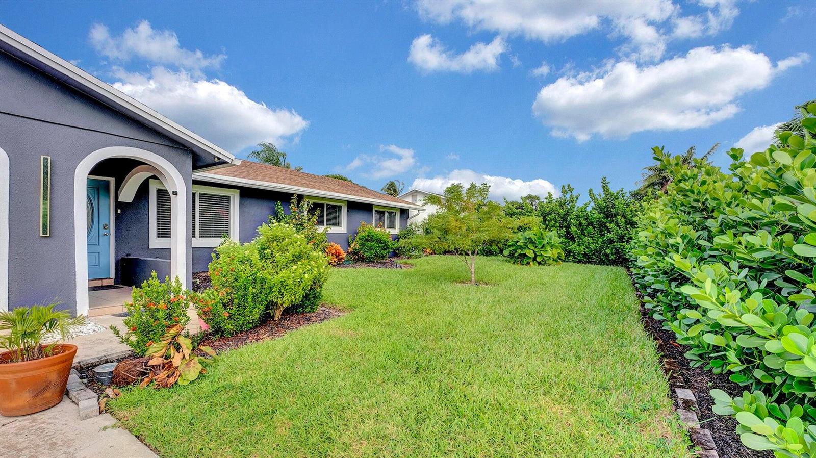 A blue house with a front door and a green lawn bordered by hedges — 2941 Angler Drive, Delray Beach FL 33445, DELRAY BEACH, FL