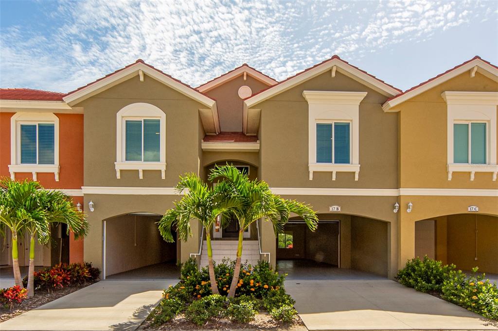 A multi-unit residential building features stucco facades, arched garage openings, and palm trees in front — 17B FRANKLIN COURT S, ST PETERSBURG, FL