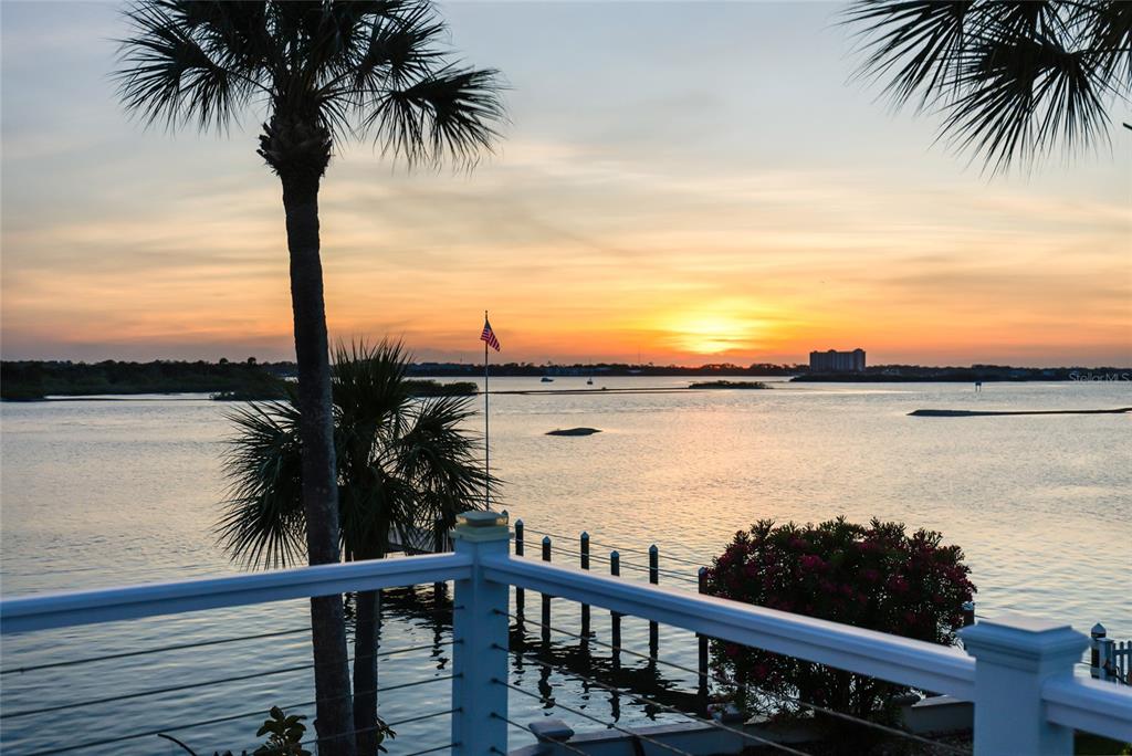 A view of a sunset over a body of water from a balcony with railings — 122 CORAL WAY, PORT ORANGE, FL