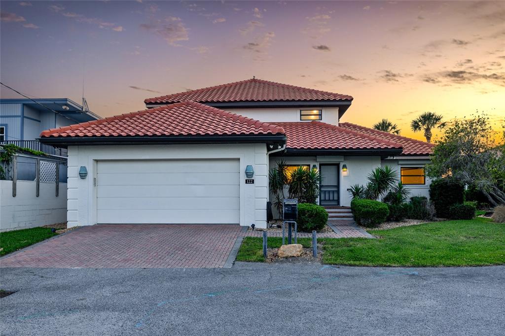 A single-story house with a white exterior, red tile roof, and a two-car garage — 122 CORAL WAY, PORT ORANGE, FL