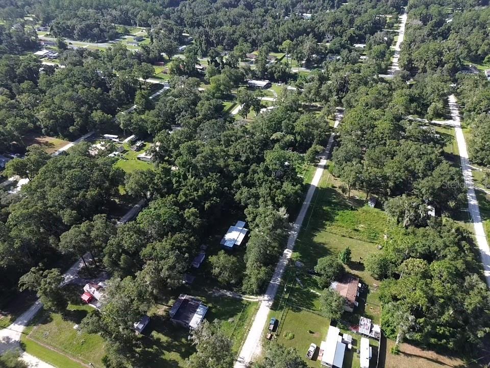 An aerial view shows a rural residential area with scattered houses nestled among dense trees — TBD NW 136TH COURT, OCALA, FL