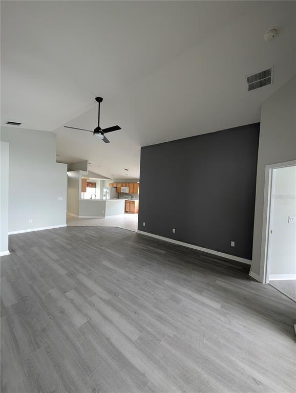 A living room with gray wood-look flooring and a large dark gray accent wall — 732 HENLEY CIRCLE, DAVENPORT, FL