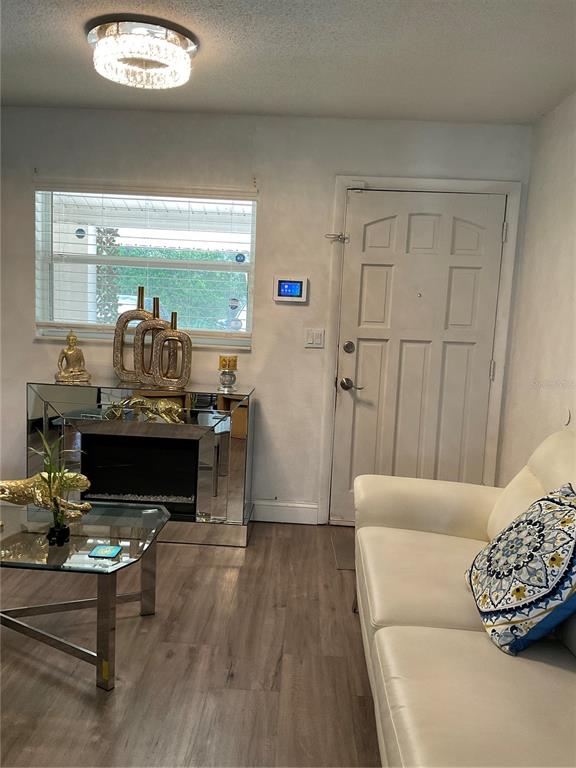 A living room features a white sofa, a mirrored console table, and a glass coffee table — 837 CAMPELLO STREET, ALTAMONTE SPRINGS, FL