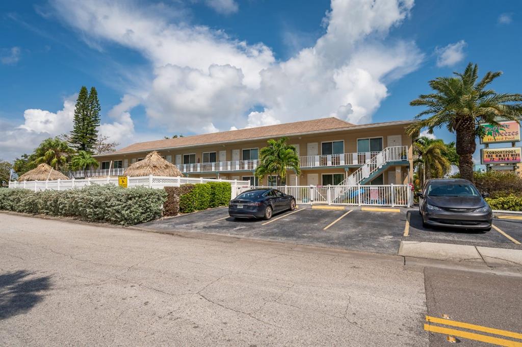 A two-story motel building with a parking lot, palm trees, and a white fence — 14251 GULF BOULEVARD UNIT 12, ST PETERSBURG, FL