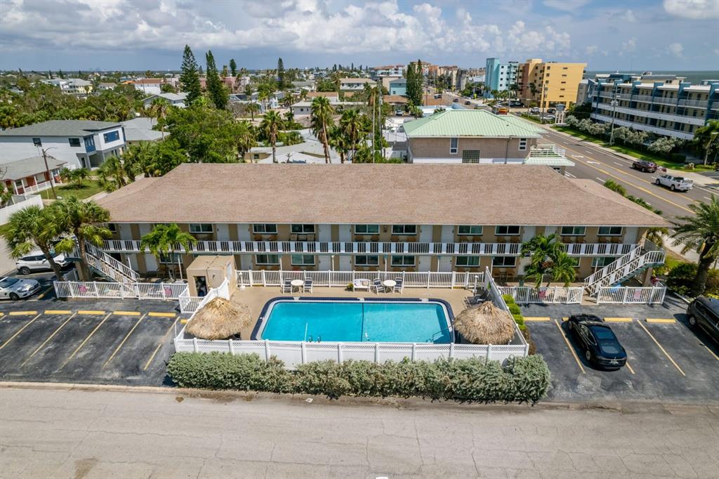 An aerial view shows a two-story motel building with a swimming pool and parking lot — 14251 GULF BOULEVARD UNIT 12, ST PETERSBURG, FL