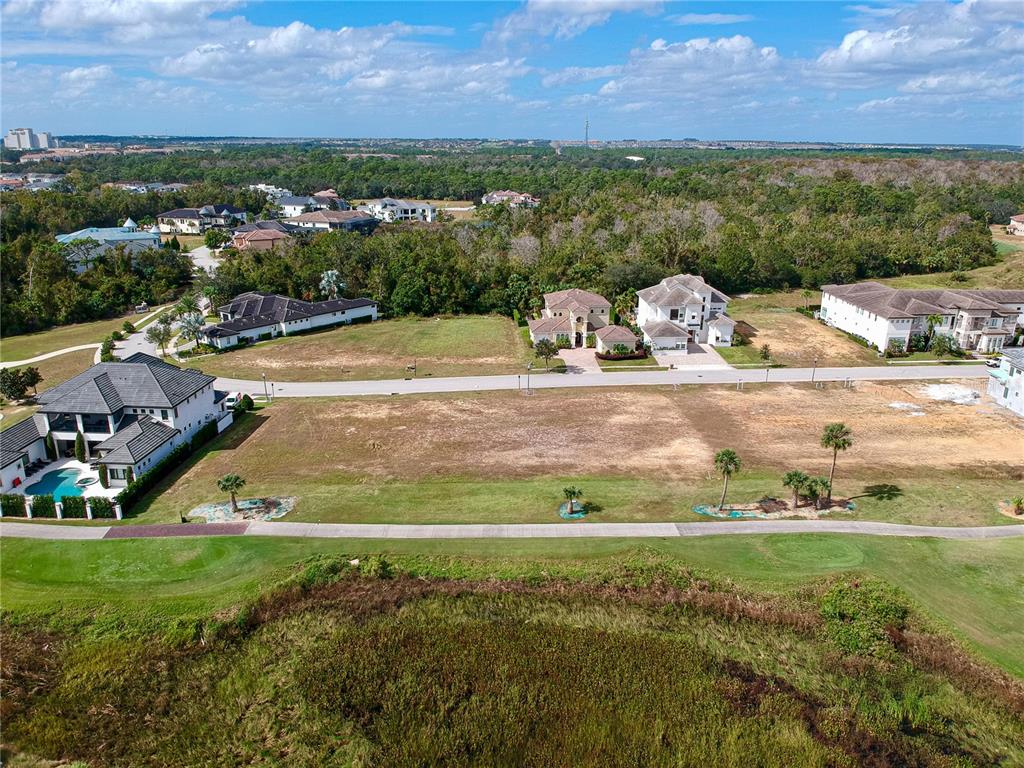 An aerial view shows several residential lots and houses bordering a golf course — 1161 GRAND TRAVERSE PARKWAY, REUNION, FL