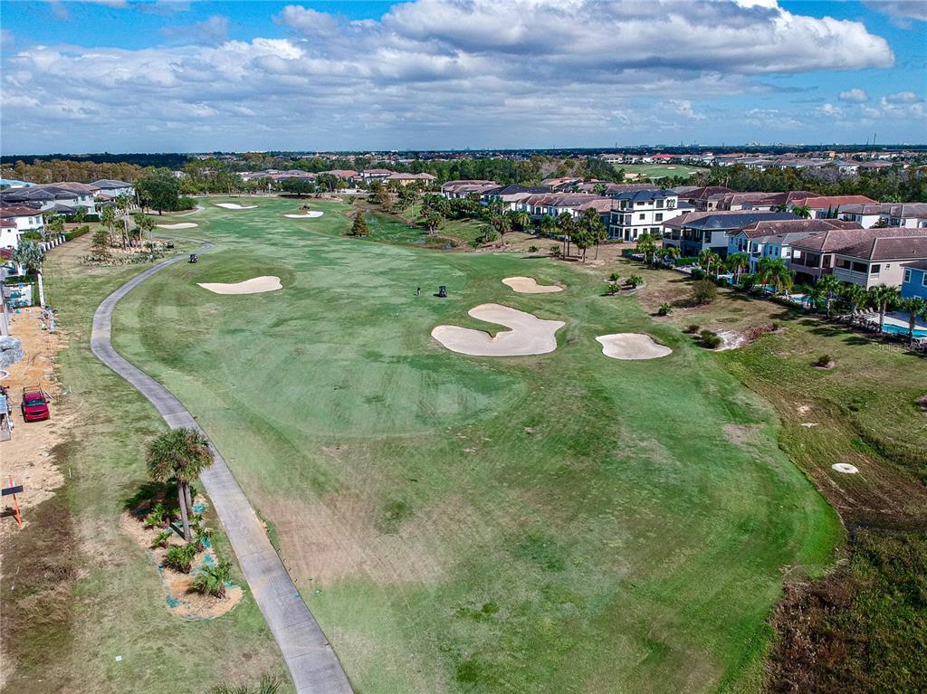 An aerial view of a golf course fairway lined with residential houses and palm trees — 1161 GRAND TRAVERSE PARKWAY, REUNION, FL