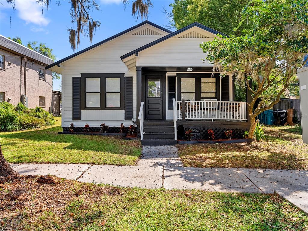 A single-story house with white siding, dark trim, and a front porch with white railings — 412 E HARWOOD STREET UNIT 1, ORLANDO, FL