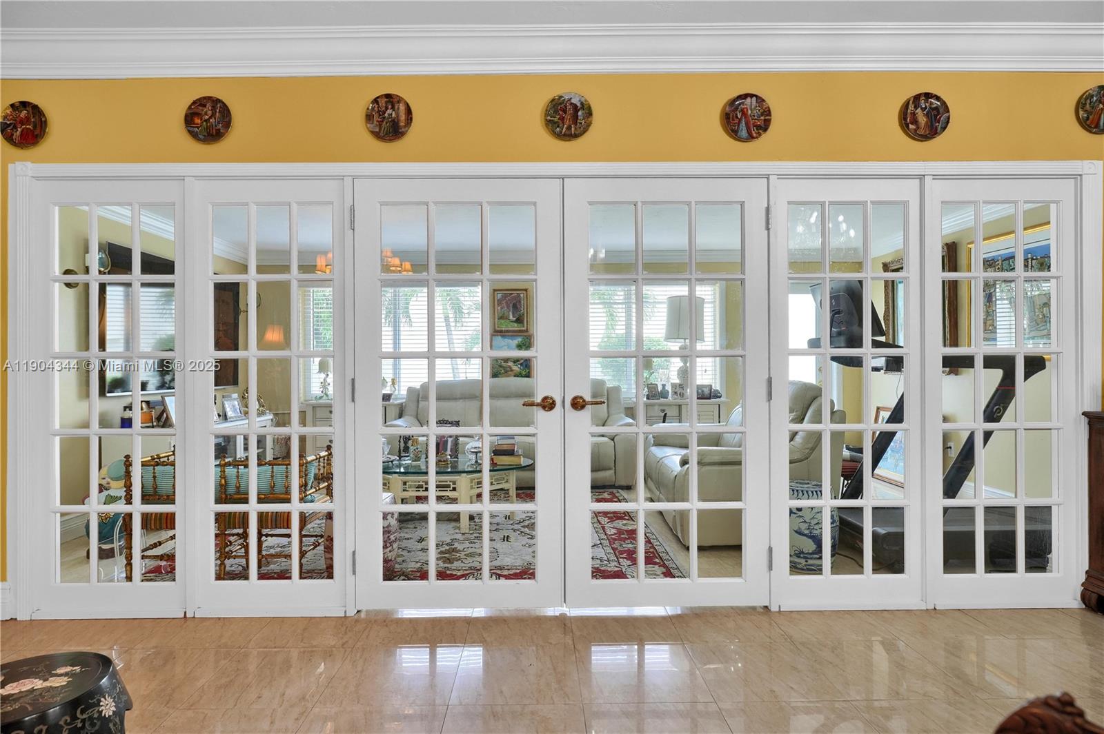 A set of white French doors separates a tiled room from a living area — 1407 San Marco Ave, Coral Gables FL 33134, CORAL GABLES, FL