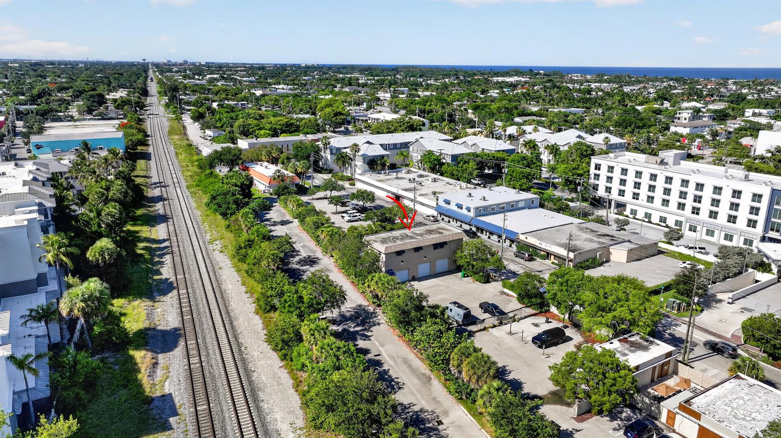 An aerial view shows a small commercial building next to railroad tracks in a city — 234 NE 4th Avenue, Delray Beach FL 33483, DELRAY BEACH, FL