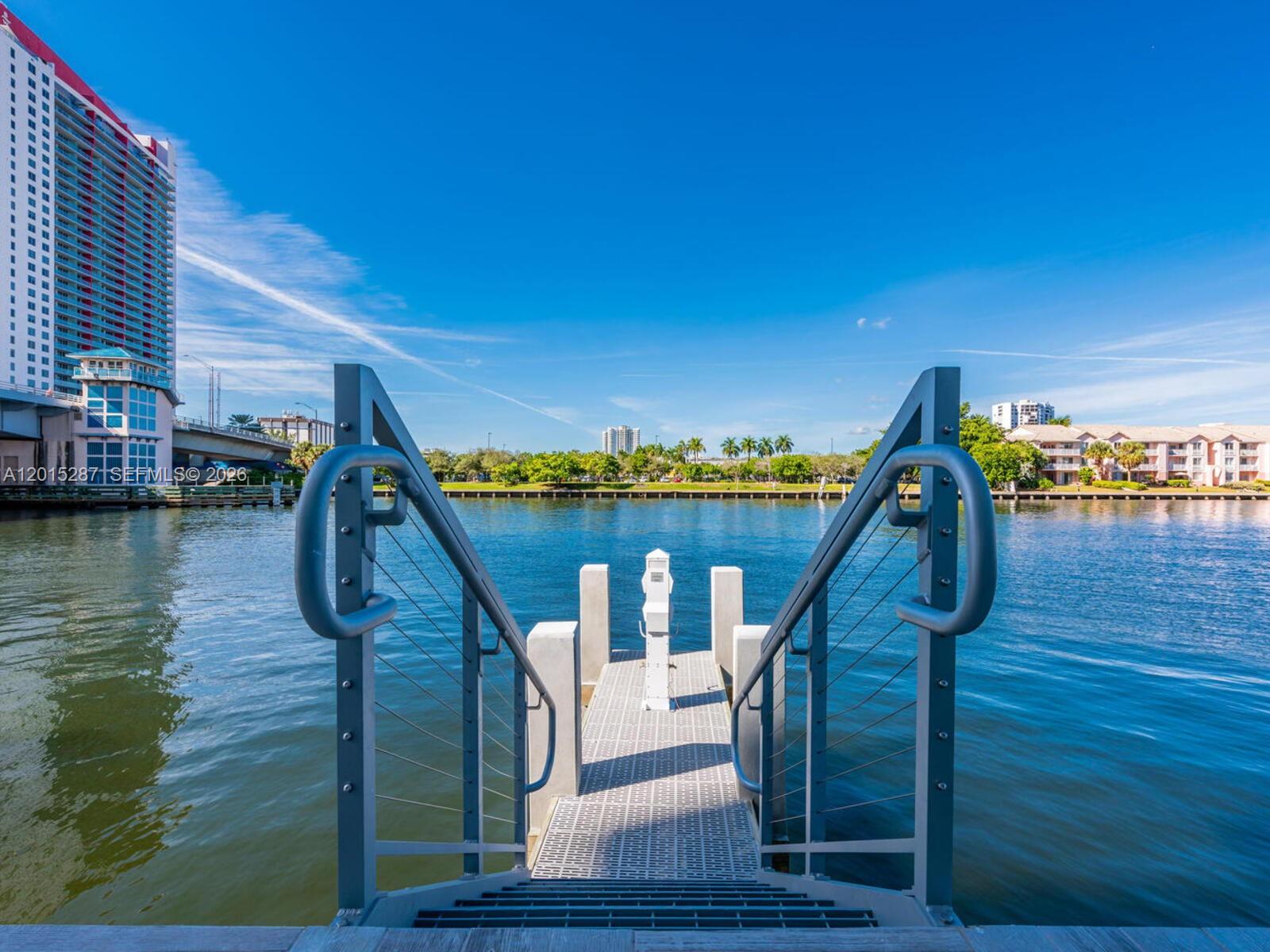 A metal staircase leads down to a floating dock on a calm waterway — 4010 S Ocean Dr # R2004, Hollywood FL 33019, HOLLYWOOD, FL