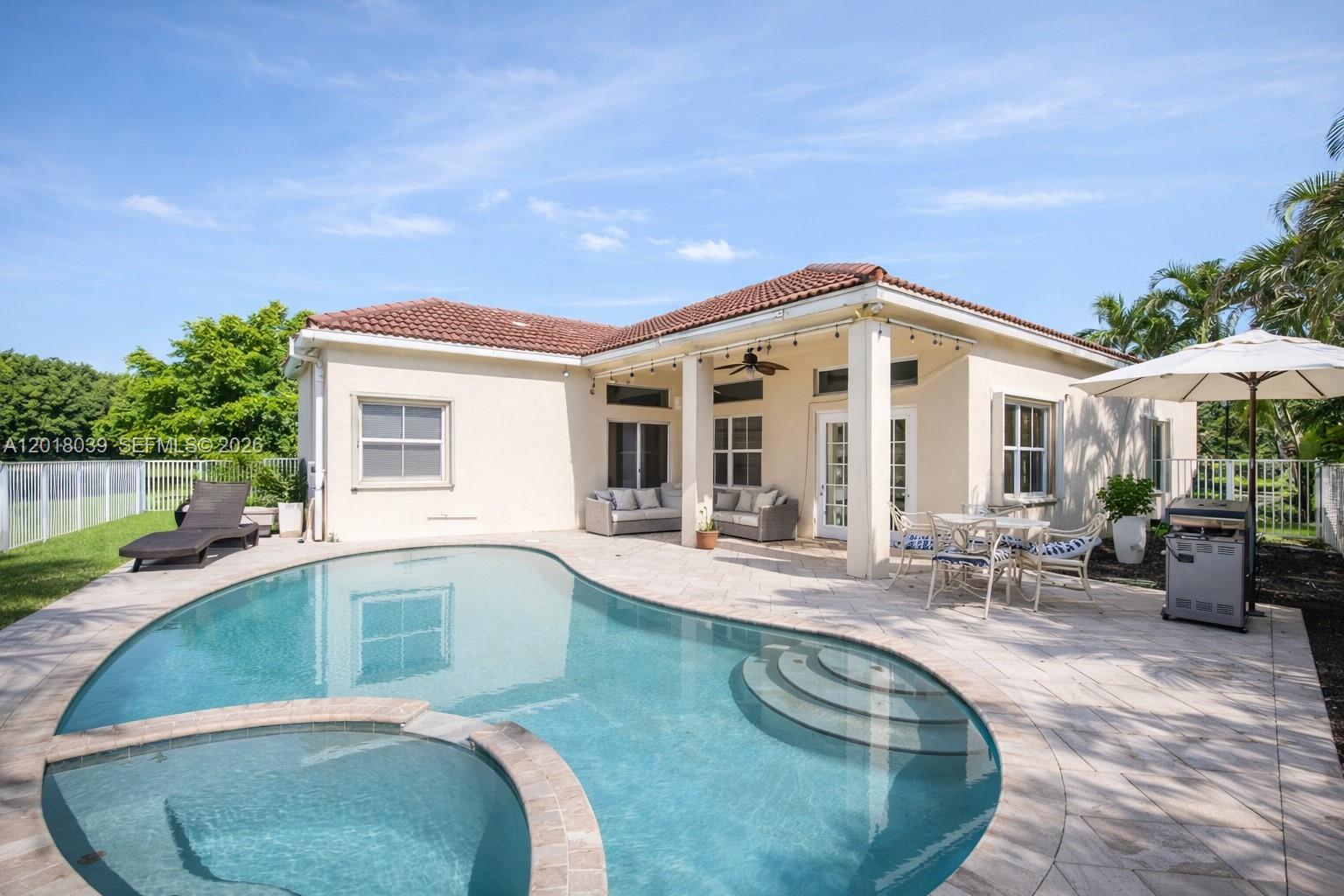 A backyard features a swimming pool with a spa, patio furniture, and a covered porch — 777 Tanglewood Cir, Weston FL 33327, WESTON, FL