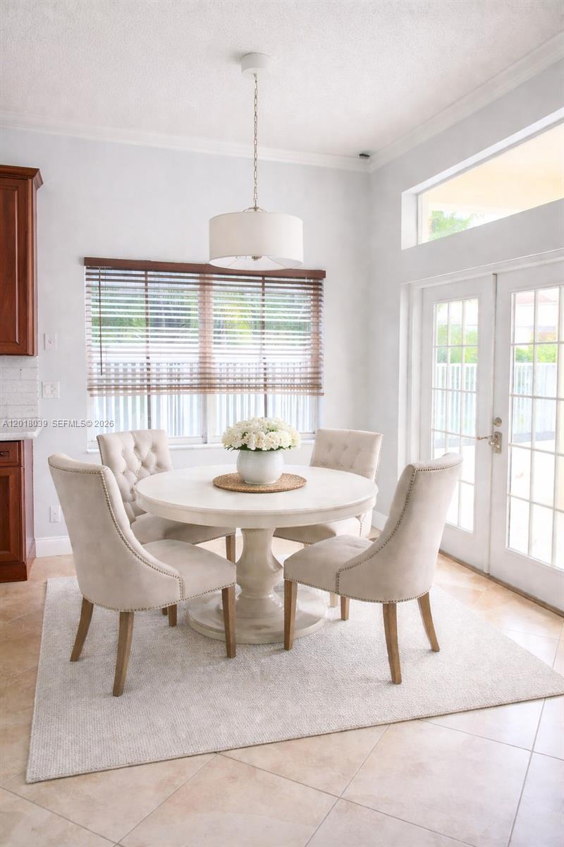 A dining area features a round white table, four upholstered chairs, and a pendant light — 777 Tanglewood Cir, Weston FL 33327, WESTON, FL